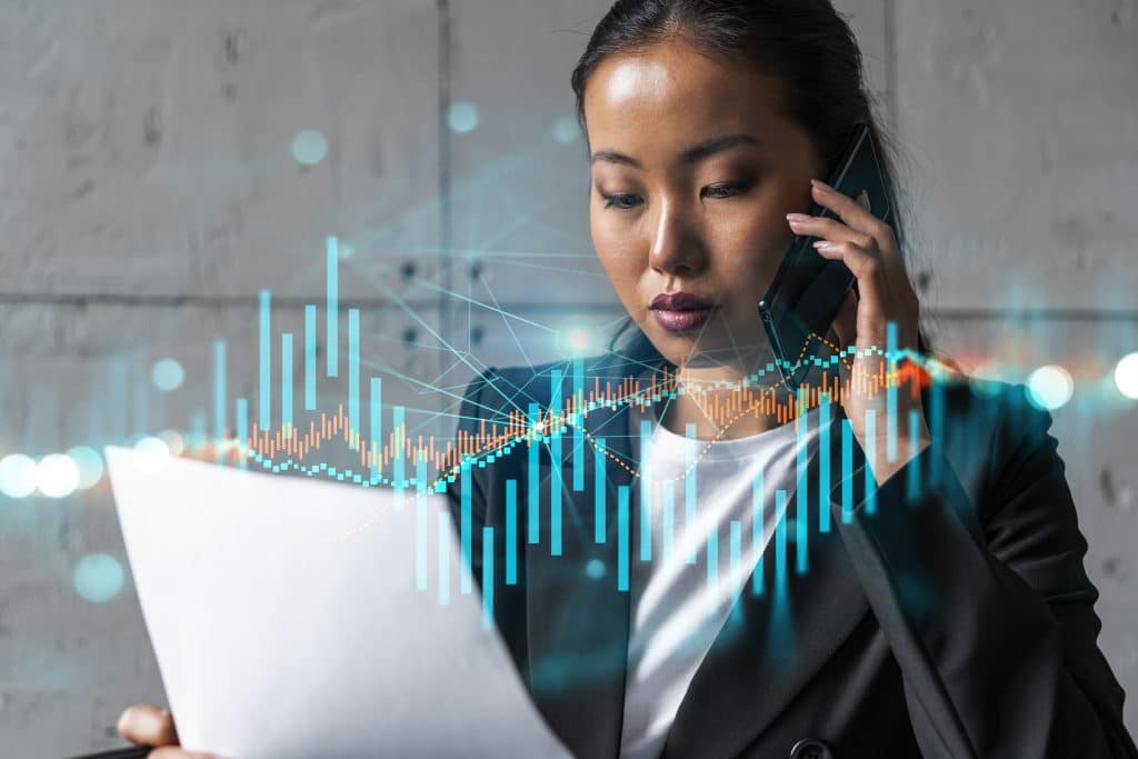 Businesswoman speaks phone and stock market financial chart hologram. Double exposure. Online trading bonds, shares and currencies concept.